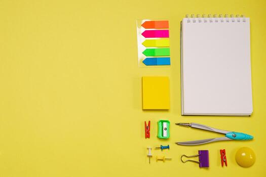 Notebook on a spring for notes and stationery lie on a yellow background photo