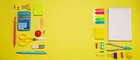 Notebook on a spring for notes and stationery lie on a yellow background photo