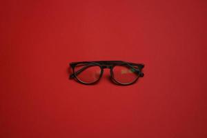 Plastic card style fashion glasses style isolated on dark red background photo