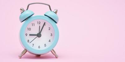 Blue alarm clock on a pink background. Copy space. Close-up. Deadline concept. photo