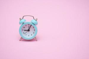 Blue alarm clock on a pink background. Copy space. Close-up. Deadline concept. photo