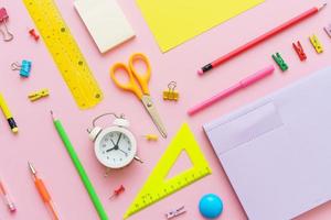 School supplies, stationery on pink background. Pens pencils notepad. Flat lay photo