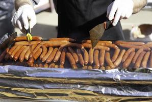 Hands cooking sausage on the grill photo