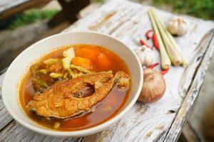 Tamarind curry with fried fish and vegetables on wooden floor - Thai style  That is delicious and has been very popular. photo