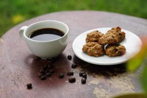 Black coffee cup with cookies on wooden floor, black coffee in the morning to drink with cookies. photo