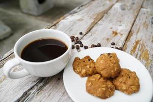 Black coffee cup with cookies on wooden floor, black coffee in the morning to drink with cookies. photo