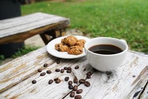 Black coffee cup with cookies on wooden floor, black coffee in the morning to drink with cookies. photo