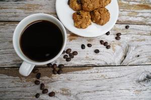 Black coffee cup with cookies on wooden floor, black coffee in the morning to drink with cookies. photo