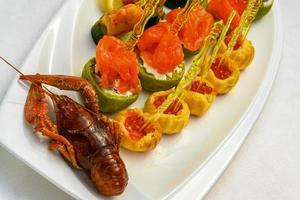 A closeup shot of cooked cancer with appetizers on skewers on the plate photo