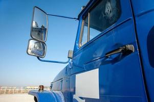 A closeup of an blue dump truck door with rear view mirror at a construction site photo