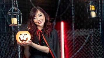 Portrait beautiful woman wearing witch costume holding pumkin in halloween theme. photo