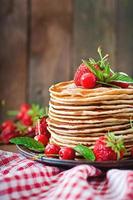 Pancakes with berries and syrup in a rustic style photo