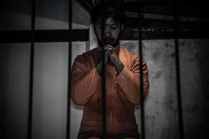 retrato de un hombre desesperado por atrapar la prisión de hierro, el concepto de prisionero, la gente de tailandia, la esperanza de ser libre, si violan la ley serían arrestados y encarcelados. foto