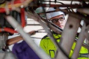 técnico arreglando el motor del avión, ingeniería aeroespacial masculina revisando los motores de los aviones, el mantenimiento mecánico asiático inspecciona el motor del avión foto