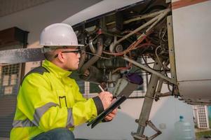 técnico arreglando el motor del avión, ingeniería aeroespacial masculina revisando los motores de los aviones, el mantenimiento mecánico asiático inspecciona el motor del avión foto