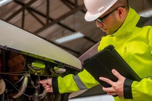 Technician fixing the engine of the airplane,Male aerospace engineering checking aircraft engines,Asian mechanic maintenance inspects plane engine photo