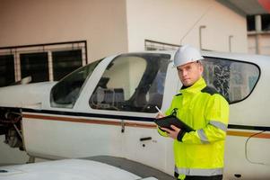 técnico arreglando el motor del avión, ingeniería aeroespacial masculina revisando los motores de los aviones, el mantenimiento mecánico asiático inspecciona el motor del avión foto