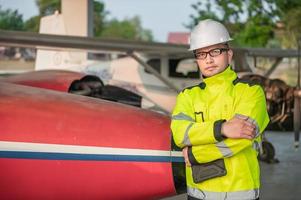 técnico arreglando el motor del avión, ingeniería aeroespacial masculina revisando los motores de los aviones, el mantenimiento mecánico asiático inspecciona el motor del avión foto