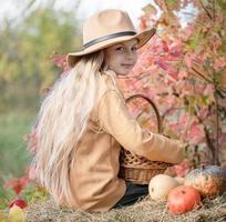 niña en el heno con calabazas foto