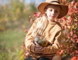 niña en el heno con calabazas foto