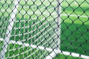 Close-up of perimeter fencing net against a soccer goal post photo