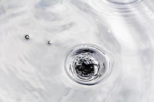 gotitas de agua o gotas de agua caen sobre la superficie del agua causando que la superficie del agua se disperse y forme espuma. foto