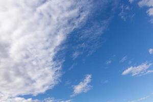 nubes blancas, flotando y formándose con un cielo azul en el fondo foto
