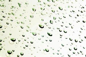 Drops of water and water beads on clear glass. photo