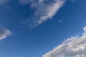 nubes blancas, flotando y formándose con un cielo azul en el fondo foto