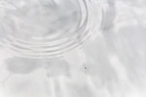 Water droplets or water beads fall on the water surface causing the water surface to disperse and foam. photo