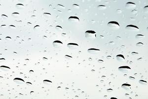 Drops of water and water beads on clear glass. photo