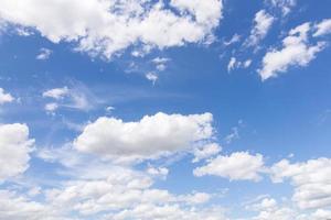 nubes blancas, flotando y formándose con un cielo azul en el fondo foto