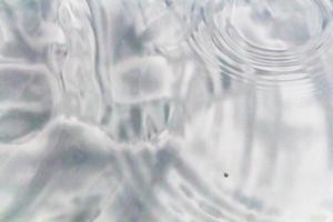 gotitas de agua o gotas de agua caen sobre la superficie del agua causando que la superficie del agua se disperse y forme espuma. foto