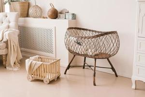 Children's wicker bed for babies in the interior of the children's room in light beige tones in the Scandinavian style photo