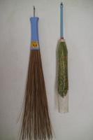 duster and broom stick hanging on the wall of the house photo