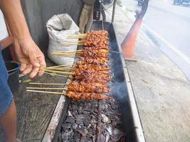 satay. is a typical indonesian food that is cooked by grilling. isolated when the process of turning satay takes place photo