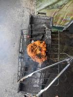 pechuga de pollo envuelta en harina crujiente con un delicioso condimento picante a la parrilla caliente.pollo asado típico de indonesia foto