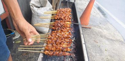 satay. is a typical indonesian food that is cooked by grilling. isolated when the process of turning satay takes place photo