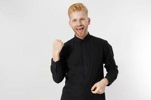 Close up of happy young european guy in black shirt. Life winner concept. Stylish young entrepreneur. Male startup concept. Copy space photo