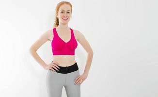 Young red haired girl in sport wear clothes isolated on white background. Slim body figure and healthy lifestyle. Fitness and sports concept. Banner photo