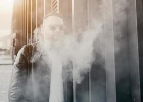 handsome guy smoking an electronic cigarette photo