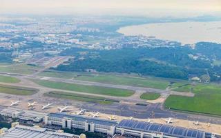 volando por encima de las nubes y el paisaje del aeropuerto de singapur. foto