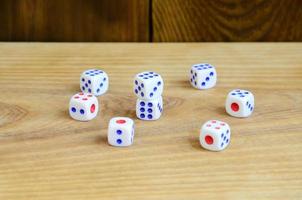 A few dice lies on the surface of natural wood. Items for generating numbers from one to six in the form of points that are painted on the side of cubes. The concept of gambling photo