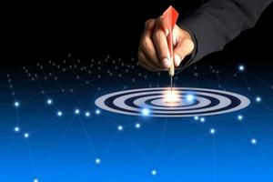 one dart hit it's target on a red background, concept for success, photo