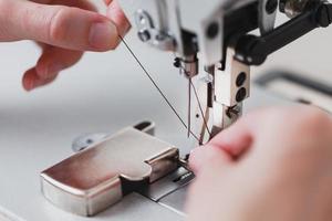 A leather craftsman produces leather goods on a sewing machine in his shop. photo