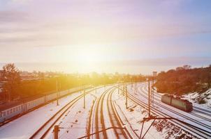 Winter landscape with a railway train against a cloudy sky background photo