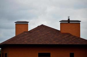 The house is equipped with high-quality roofing of shingles bitumen tiles. A good example of perfect roofing. The roof is reliably protected from adverse weather conditions photo