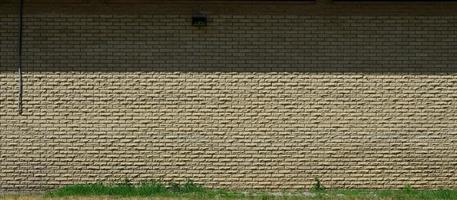 Texture of brick wall from relief stones under bright sunlight photo