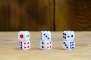 A few dice lies on the surface of natural wood. Items for generating numbers from one to six in the form of points that are painted on the side of cubes. The concept of gambling photo