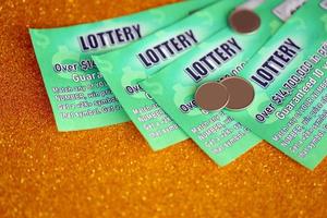 Close up view of green lottery scratch cards. Many used fake instant lottery tickets with gambling results. Gambling addiction photo